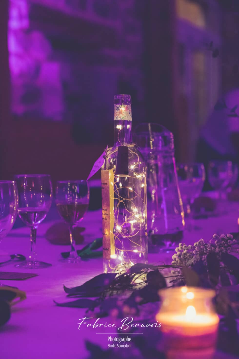 Bouteille délicatement illuminée sur la table des mariées